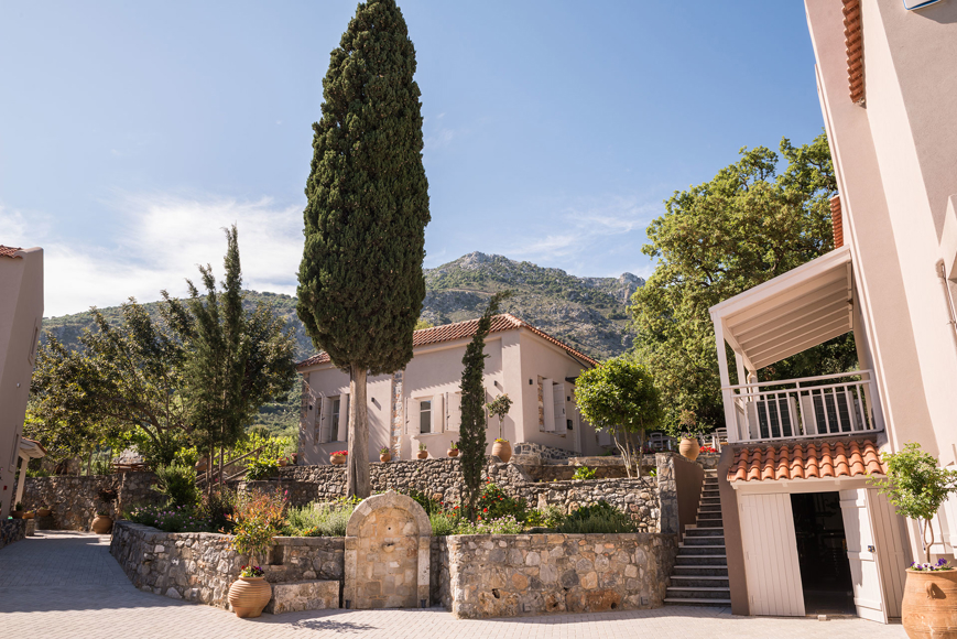 Charming stone pathways and traditional architecture surrounded by lush greenery at Avdou Collection Crete