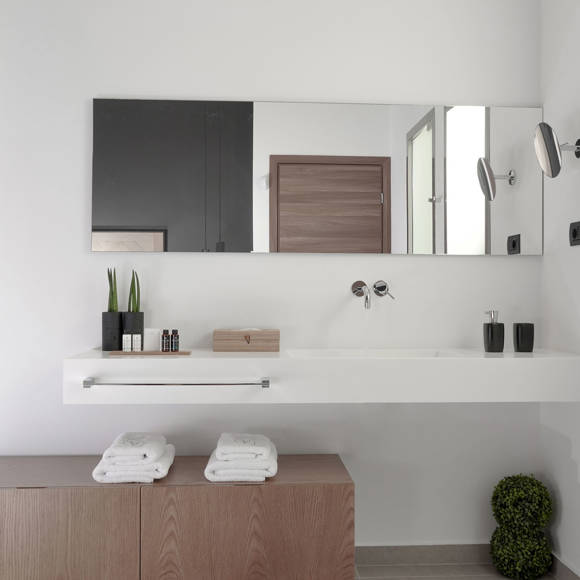 Modern bathroom with wide mirror, double sink, fresh towels and luxury amenities in the two bedroom grand villa