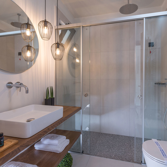 Stylish bathroom with walk in shower, round mirror and modern lighting at Avdou Collection Crete