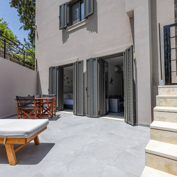 Suite's terrace with sun loungers, seating area and staircase at Avdou Collection Crete