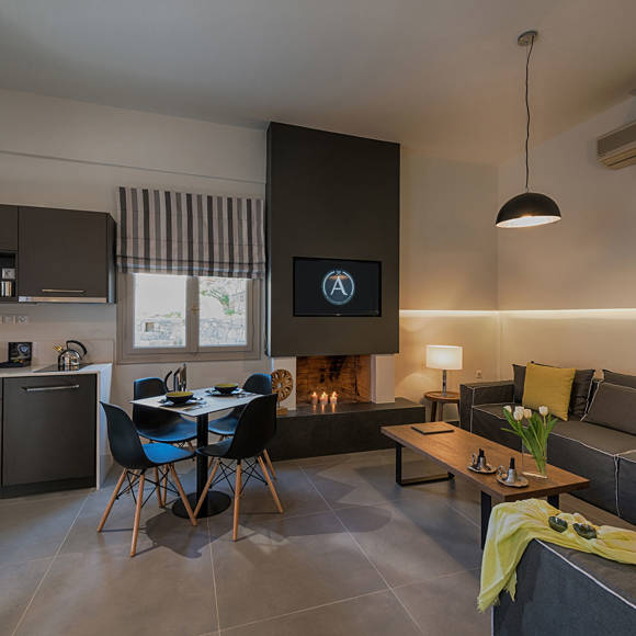 Open plan suite living room with kitchen, dining area and cozy seating at Avdou Collection Crete