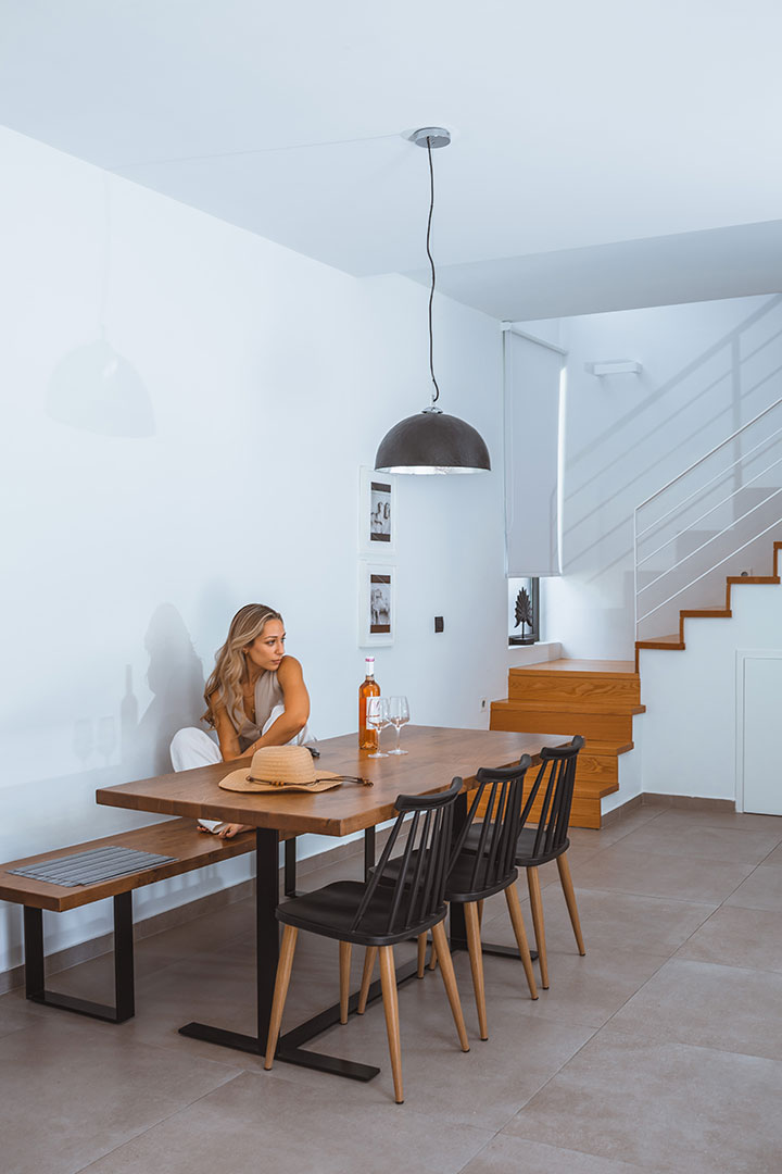Modern villa interior with wooden dining table, stylish chairs and natural light at Avdou Collection Crete