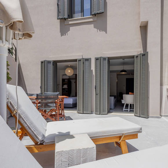Suite's luxurious outdoor terrace with sun loungers and umbrellas at Avdou Collection Crete
