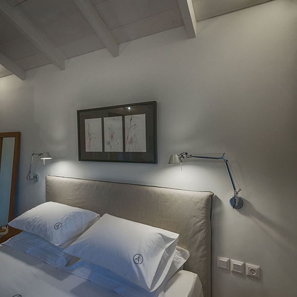 Junior villas master bedroom with double bed, framed artwork and modern design with natural colors at Avdou Collection