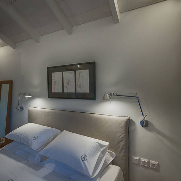 Junior villas master bedroom with double bed, framed artwork and modern design with natural colors at Avdou Collection