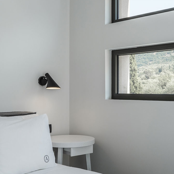 Grand villa with three bedrooms featuring bright interiors, soft bedding and window views of the Cretan landscape
